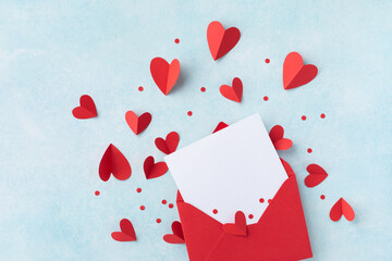 Saint Valentine day holiday background with envelope, paper card and various red hearts for love...