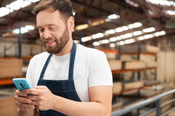 focused businessman using mobile phone to work and view request at warehouse
