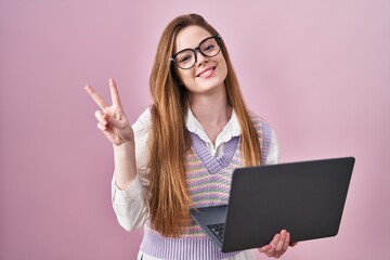 Young caucasian woman working using computer laptop smiling with happy face winking at the camera...