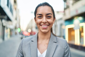 Young beautiful hispanic woman executive smiling confident standing at street