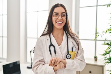 Young beautiful hispanic woman doctor smiling confident standing at clinic