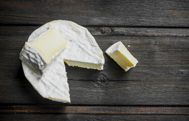 Brie cheese on wooden background.