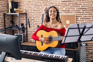 Fototapeta na wymiar Young african american woman musician playing classical guitar at music studio