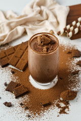 iced chocolate drink sprinkle with cocoa powder decorate with chocolate bar and white cotton and biscuit in the white backdrop