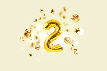 Golden number 2 is flying with golden confetti, gifts, mirror ball and stars balloons on a beige...