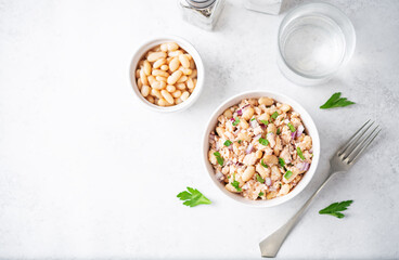 Cooked salmon white bean red onion salad in a bowl