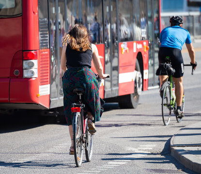 Bicyclists commuting in summer Stockholm traffic. Bus in background.