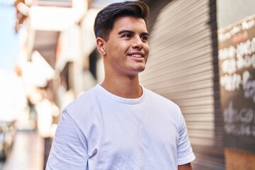 Fototapeta premium Young hispanic man smiling confident looking to the side at street