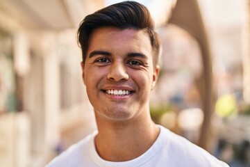 Young hispanic man smiling confident standing at street