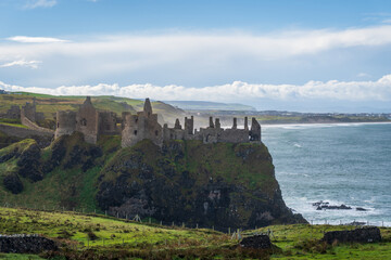 Fototapeta na wymiar Dunluce Castle ruined medieval castle in Northern Ireland, seat of Clan MacDonnell. Dramatic setting on steep cliff to Irish Sea. Inhabited by both the feuding McQuillan and MacDonnell clans.