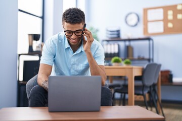 Obraz premium African american man business worker talking on the smartphone using laptop at office
