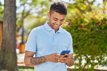 African american man smiling confident using smartphone at park