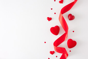 Valentines Day concept. Flat lay composition of red hearts and silk ribbon on white background with copy space. Lovers holiday card idea.