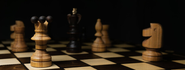 Chess game. A wooden chess piece on a chess board. Panorama photo, background for banner on...