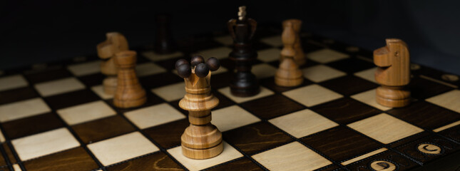 Chess game. A wooden chess piece on a chess board. Panorama photo, background for banner on website. Logic game. Chess tournament.
