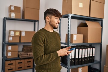 Young arab man ecommerce business worker using smartphone at office