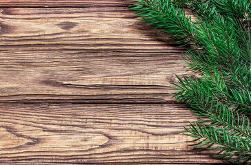 New Year composition from a fresh branch of a Christmas tree on a wooden background