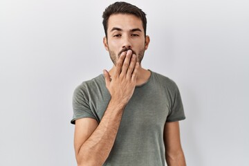 Fototapeta na wymiar Young hispanic man with beard wearing casual t shirt over white background bored yawning tired covering mouth with hand. restless and sleepiness.