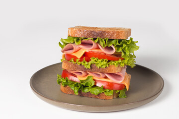Club sandwich with ham, cheese, tomato and lettuce. 