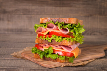 Club sandwich with ham, cheese, tomato and lettuce. 