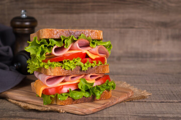 Club sandwich with ham, cheese, tomato and lettuce. 