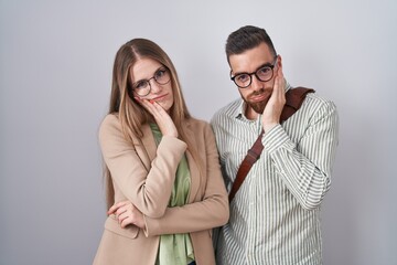 Young couple standing over white background thinking looking tired and bored with depression problems with crossed arms.