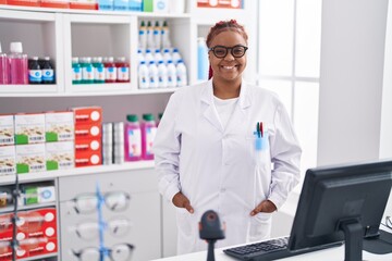 Naklejka na ściany i meble African american woman pharmacist smiling confident standing at pharmacy