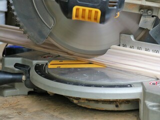 miter saw in the process of sawing a wooden plank close-up, sawing a wooden material on a miter...