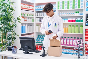 Young hispanic teenager pharmacist scanning pills at pharmacy