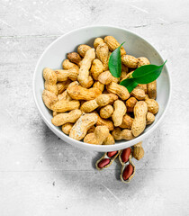 Peanuts with green leaves in the bowl .