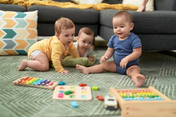 Group of toddlers playing with toys sitting on floor at home