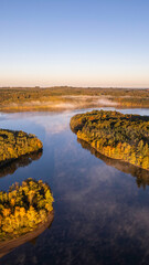 Vertical Aerial view of Lac de Saint Pardoux at sunrise in autumn with fog and mirror water