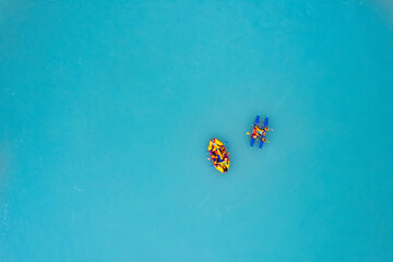 Two team extreme rafting on yellow boat on stormy blue river Altai, Aerial top view