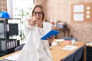 Young caucasian woman working at the office wearing glasses pointing displeased and frustrated to the camera, angry and furious with you