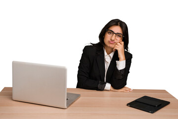 Young indian woman in a table with a laptop and tablet isolated who feels sad and pensive, looking at copy space.