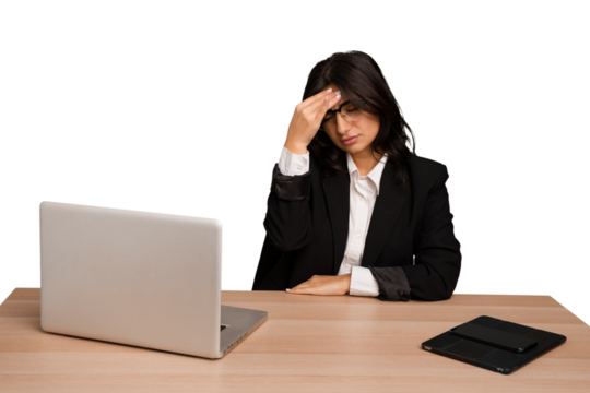 Young indian woman in a table with a laptop and tablet isolated having a head ache, touching front of the face.