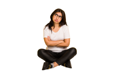 Young indian woman sitting on the floor cut out isolated tired of a repetitive task.