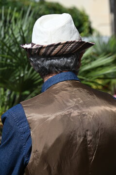 Modisch gekleideter Senior mit Jeanshemd, Weste und hellem Sommerhut