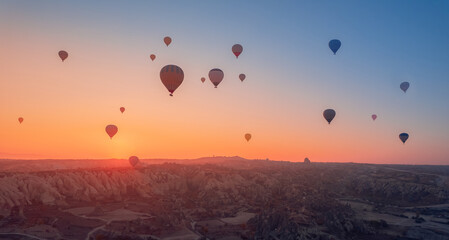 Amazing sunrise Cappadocia with set colorful hot air balloons fly in pink sky with first sun light. Turkey banner travel Concept