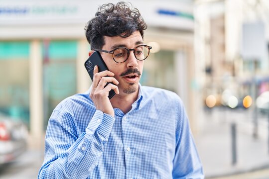 Young caucasian man talking on the smartphone with serious expression at street