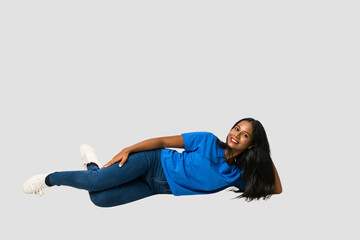 Young Indian woman sitting on the floor isolated on white background