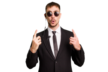 Security bodyguard man wearing a suit isolated cut out pointing upside with opened mouth.