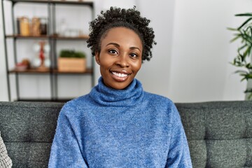 African american woman smiling confident sitting on sofa at home