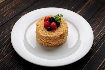 Napoleon cake with berries and mint, on a plate