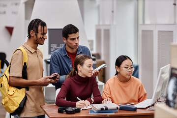 Multiethnic group of young people studying using computer together