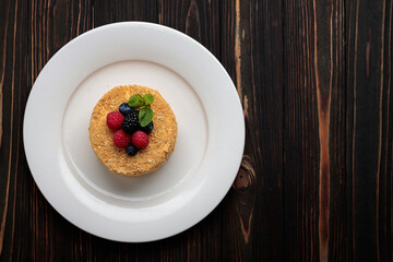 Napoleon cake with berries and mint, on a plate