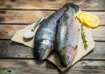 Raw sea fish with herbs and lemon wedges.