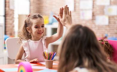 Adorable caucasian girl smiling confident high five with hands raised up at classroom