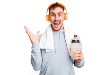 Young caucasian sporty man ready to start his gym day receiving a pleasant surprise, excited and raising hands.