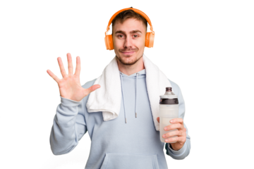 Young caucasian sporty man ready to start his gym day smiling cheerful showing number five with fingers.